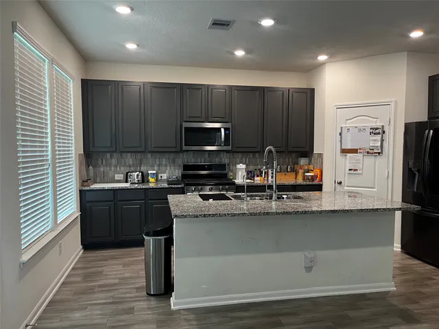 a kitchen with stainless steel appliances granite countertop a sink stove and refrigerator