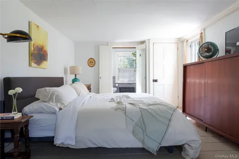 a bedroom with a bed wooden floor and window