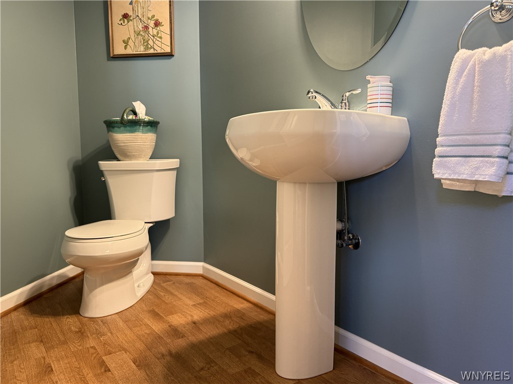 73 Chestnut Lancaster, NY 14086 - Photo 23 of 41 Warm wood floors contrast with crisp white trim and a classic pedestal sink.