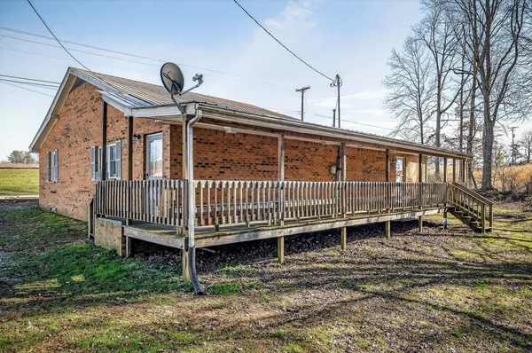 a view of a house with a yard and deck wooden floor