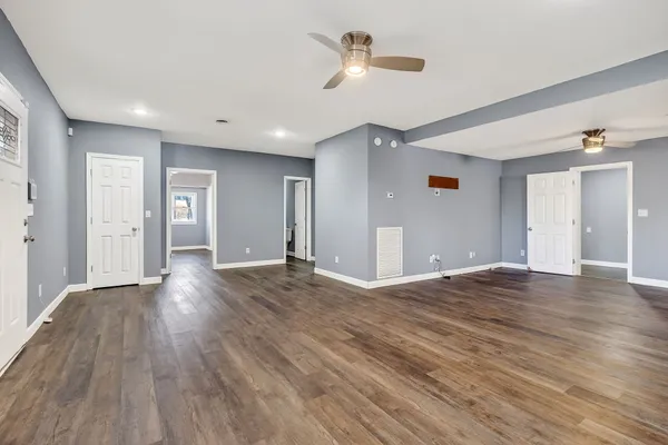 a view of empty room with wooden floor