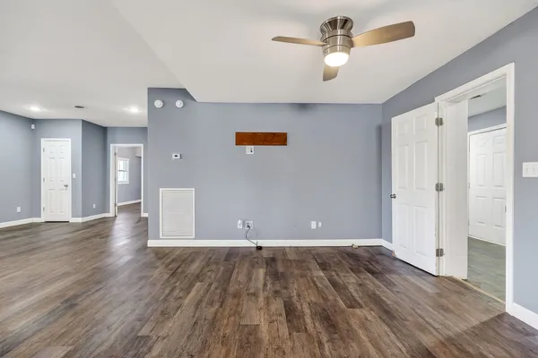 a view of empty room with wooden floor