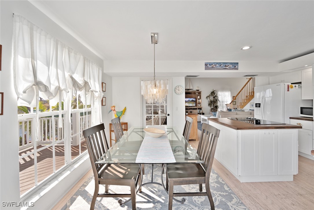 862 Beach Road Sanibel, FL 33957 - Photo 15 of 49 a dining room with furniture a chandelier and wooden floor