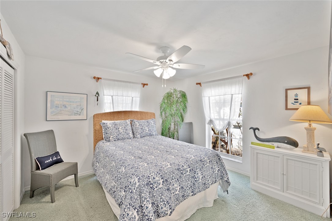 862 Beach Road Sanibel, FL 33957 - Photo 25 of 49 a bedroom with a large bed and a chandelier