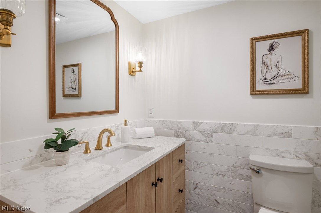 22625 Rye Road Shaker Heights, OH 44122 - Photo 21 of 38 Bathroom featuring a light wood-finish vanity with black hardware, a marble-look countertop, and a rectangular undermount sink