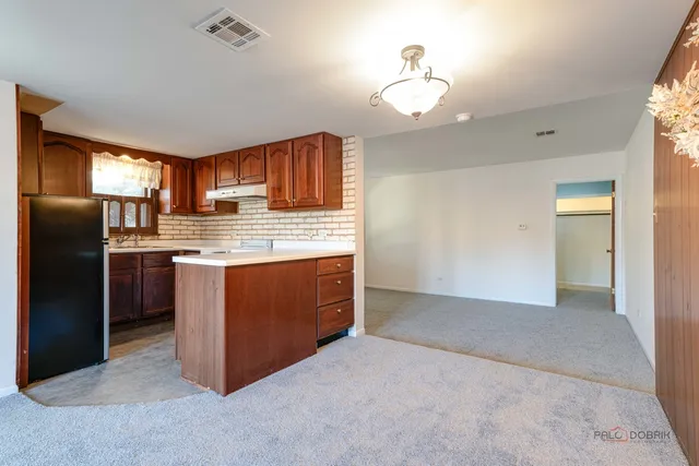 a kitchen with stainless steel appliances granite countertop a refrigerator a sink dishwasher a stove with cabinets and wooden floor