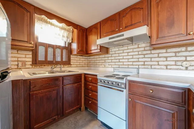 a kitchen with stainless steel appliances granite countertop a sink stove and cabinets