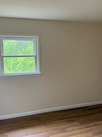 a view of a small space with wooden floor and a window