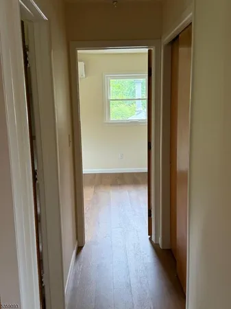 a view of a hallway with wooden floor