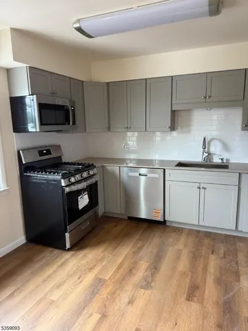 a kitchen with stainless steel appliances granite countertop a sink stove a microwave and cabinets