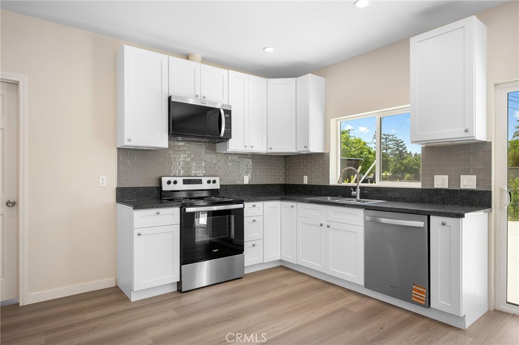 8435 Rincon Avenue Sun Valley, CA 91352 - Photo 42 of 61 a kitchen with stainless steel appliances granite countertop a stove a sink and a microwave