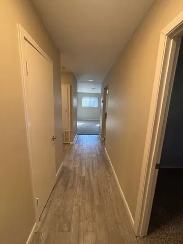 a view of a hallway with wooden floor