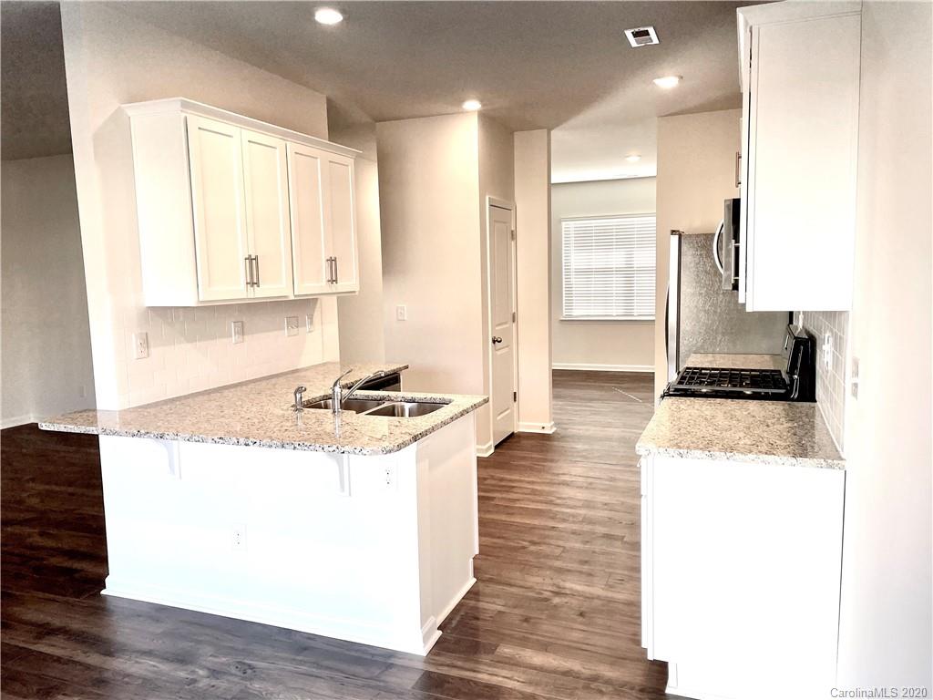 5005 Traynor Road, Unit 18 Charlotte, NC 28216 - Photo 12 of 35 a kitchen with stainless steel appliances granite countertop a stove a sink and a refrigerator