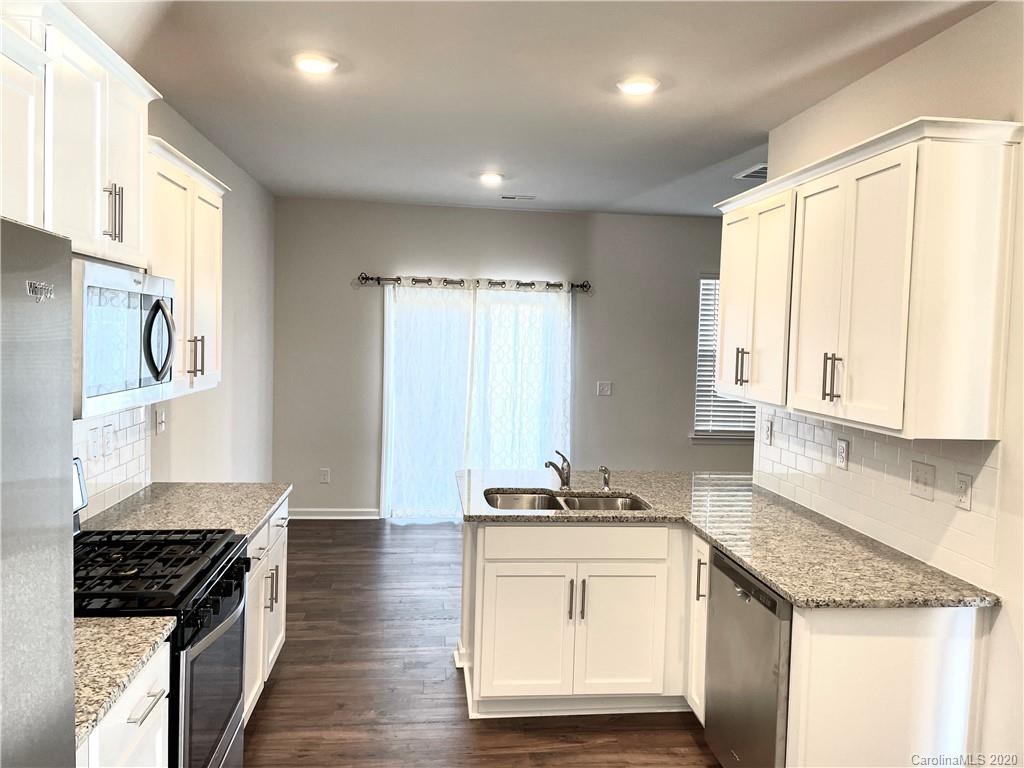 5005 Traynor Road, Unit 18 Charlotte, NC 28216 - Photo 13 of 35 a kitchen with granite countertop a sink stove and cabinets