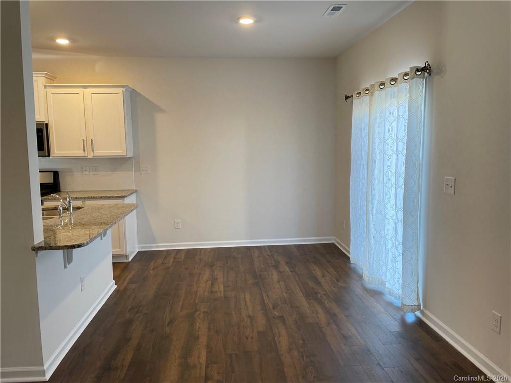 5005 Traynor Road, Unit 18 Charlotte, NC 28216 - Photo 14 of 35 a view of utility room and kitchen with wooden floor