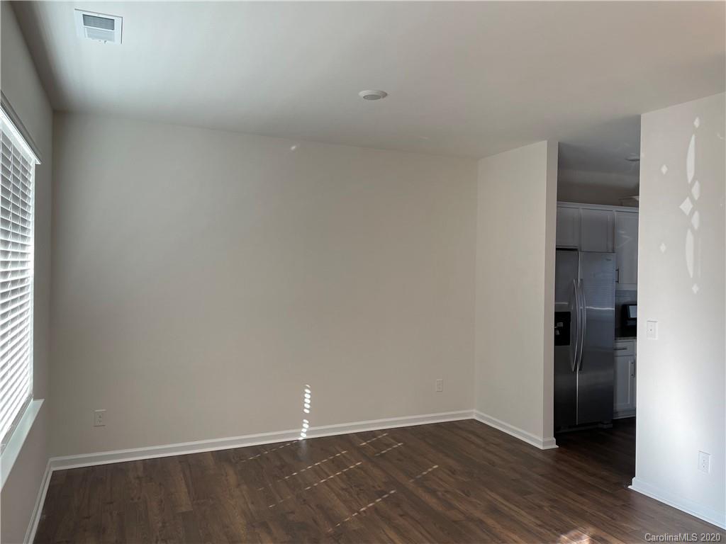 5005 Traynor Road, Unit 18 Charlotte, NC 28216 - Photo 4 of 35 a view of an empty room with wooden floor and a window