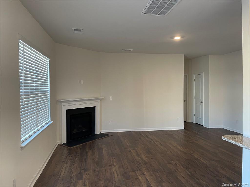 5005 Traynor Road, Unit 18 Charlotte, NC 28216 - Photo 6 of 35 an empty room with wooden floor fireplace and windows