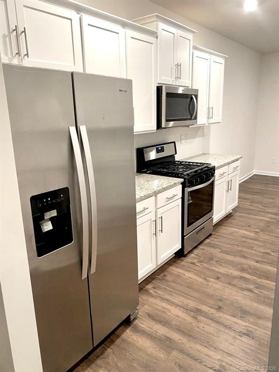 5005 Traynor Road, Unit 18 Charlotte, NC 28216 - Photo 8 of 35 a kitchen with stainless steel appliances granite countertop a refrigerator a stove a sink and a microwave