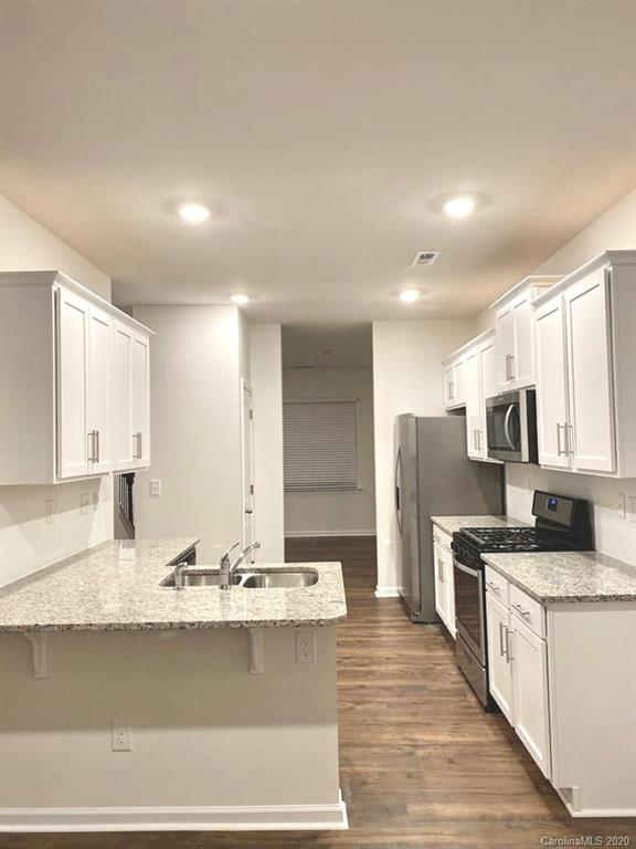 5005 Traynor Road, Unit 18 Charlotte, NC 28216 - Photo 9 of 35 a kitchen with stainless steel appliances granite countertop a sink stove and refrigerator
