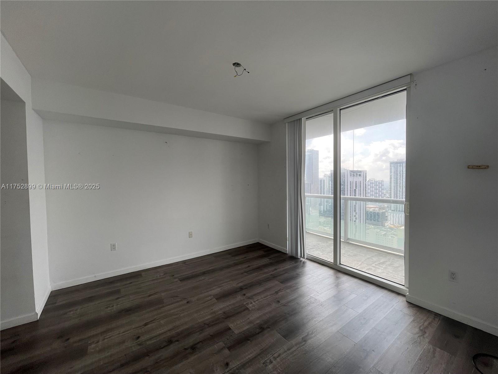 50 Biscayne Boulevard, Unit 4105 Miami, FL 33132 - Photo 11 of 41 a view of an empty room with wooden floor and a window
