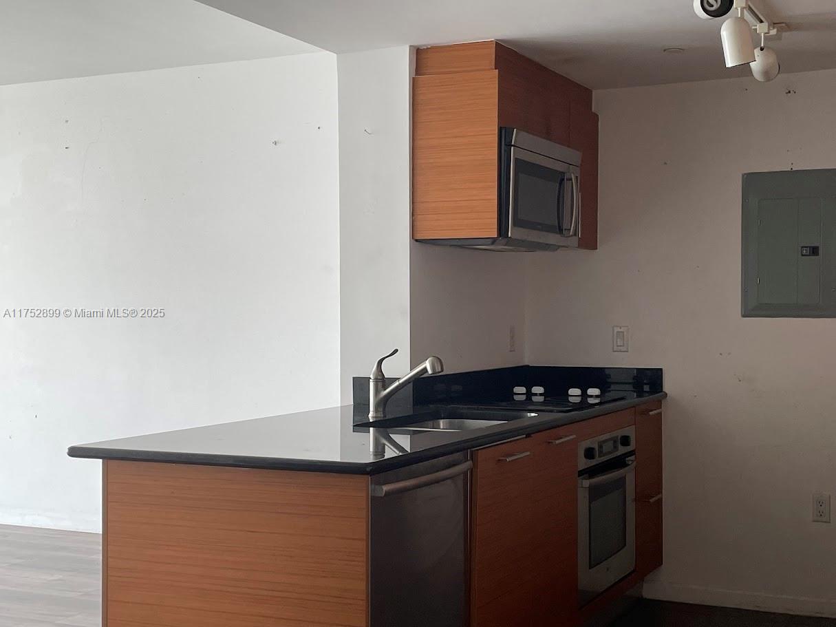 50 Biscayne Boulevard, Unit 4105 Miami, FL 33132 - Photo 34 of 41 a kitchen with granite countertop a stove and a microwave