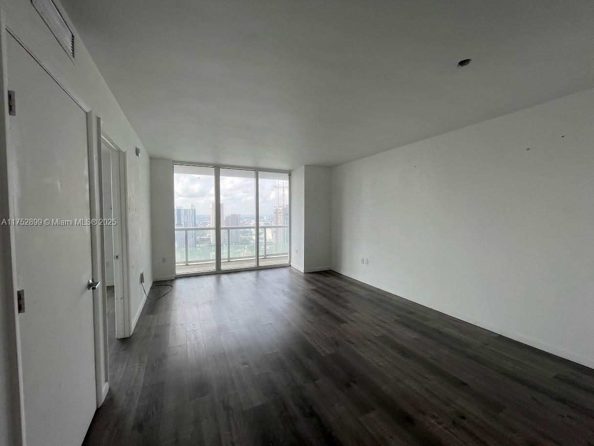50 Biscayne Boulevard, Unit 4105 Miami, FL 33132 - Photo 40 of 41 a view of an empty room with wooden floor and a window