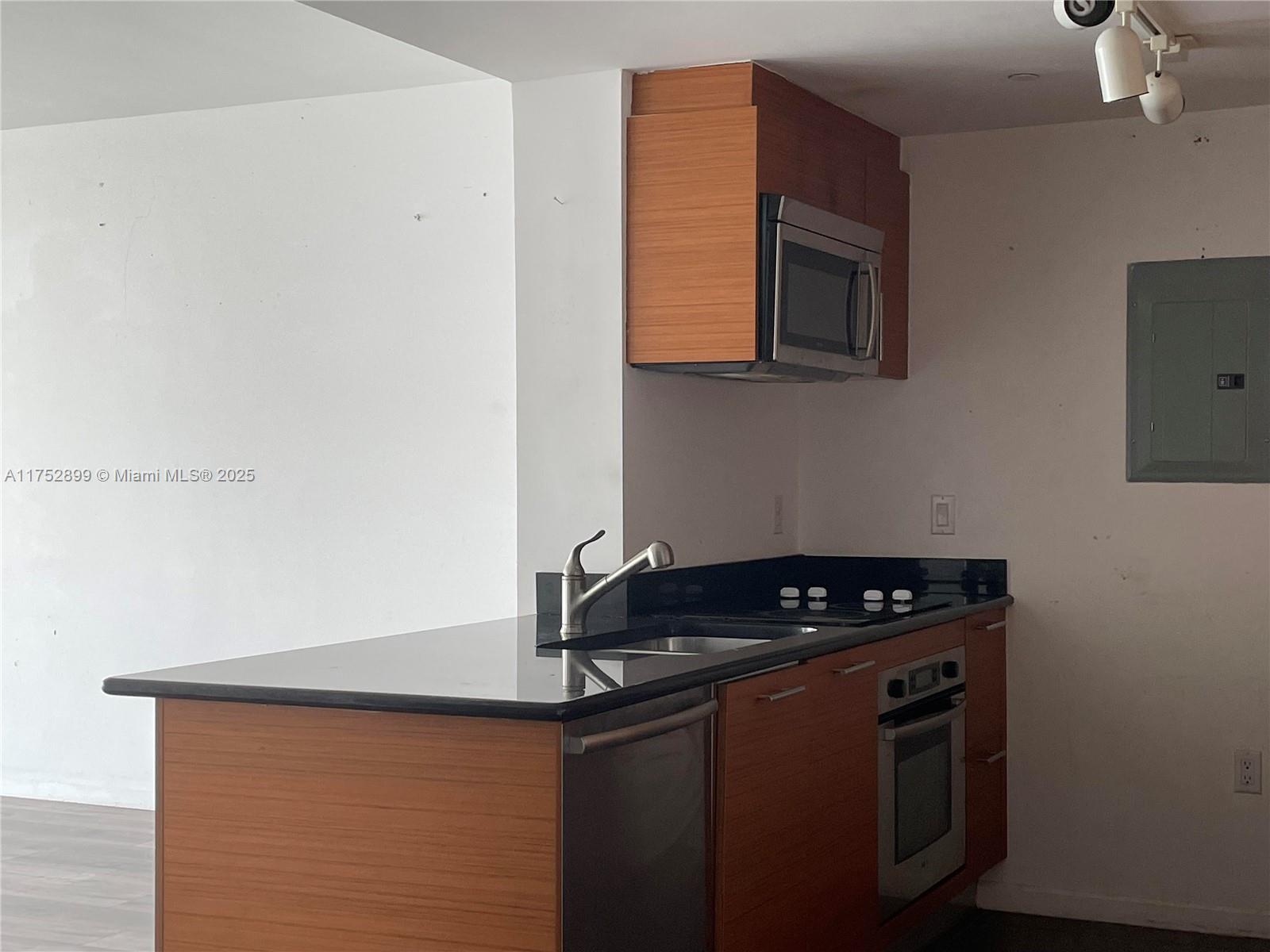 50 Biscayne Boulevard, Unit 4105 Miami, FL 33132 - Photo 6 of 41 a kitchen with granite countertop a stove and a microwave