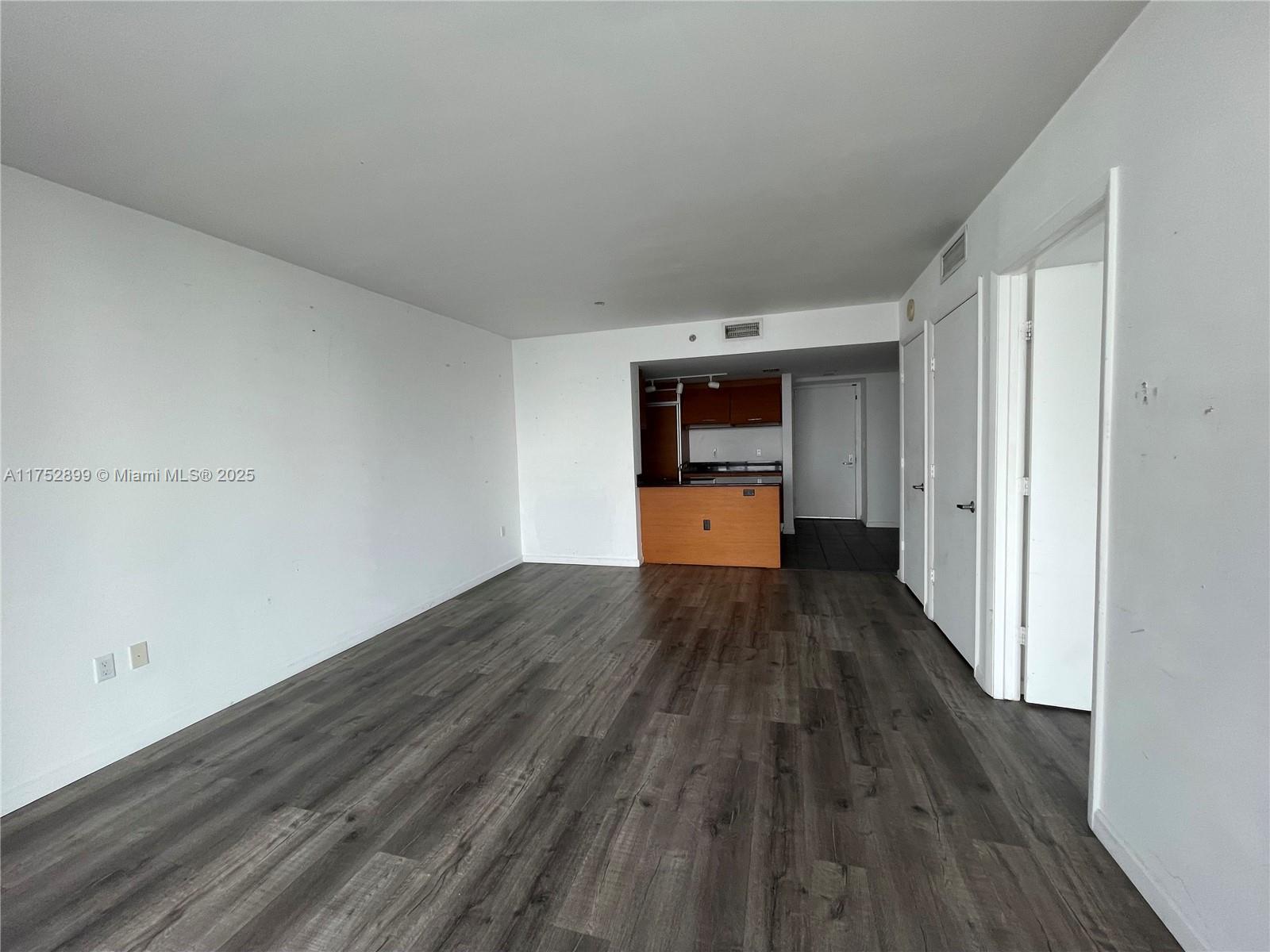 50 Biscayne Boulevard, Unit 4105 Miami, FL 33132 - Photo 9 of 41 wooden floor in an empty room and a kitchen