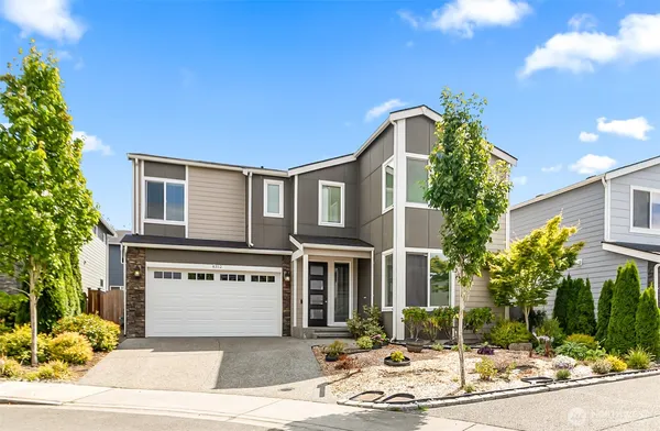 a front view of a house with a yard and garage