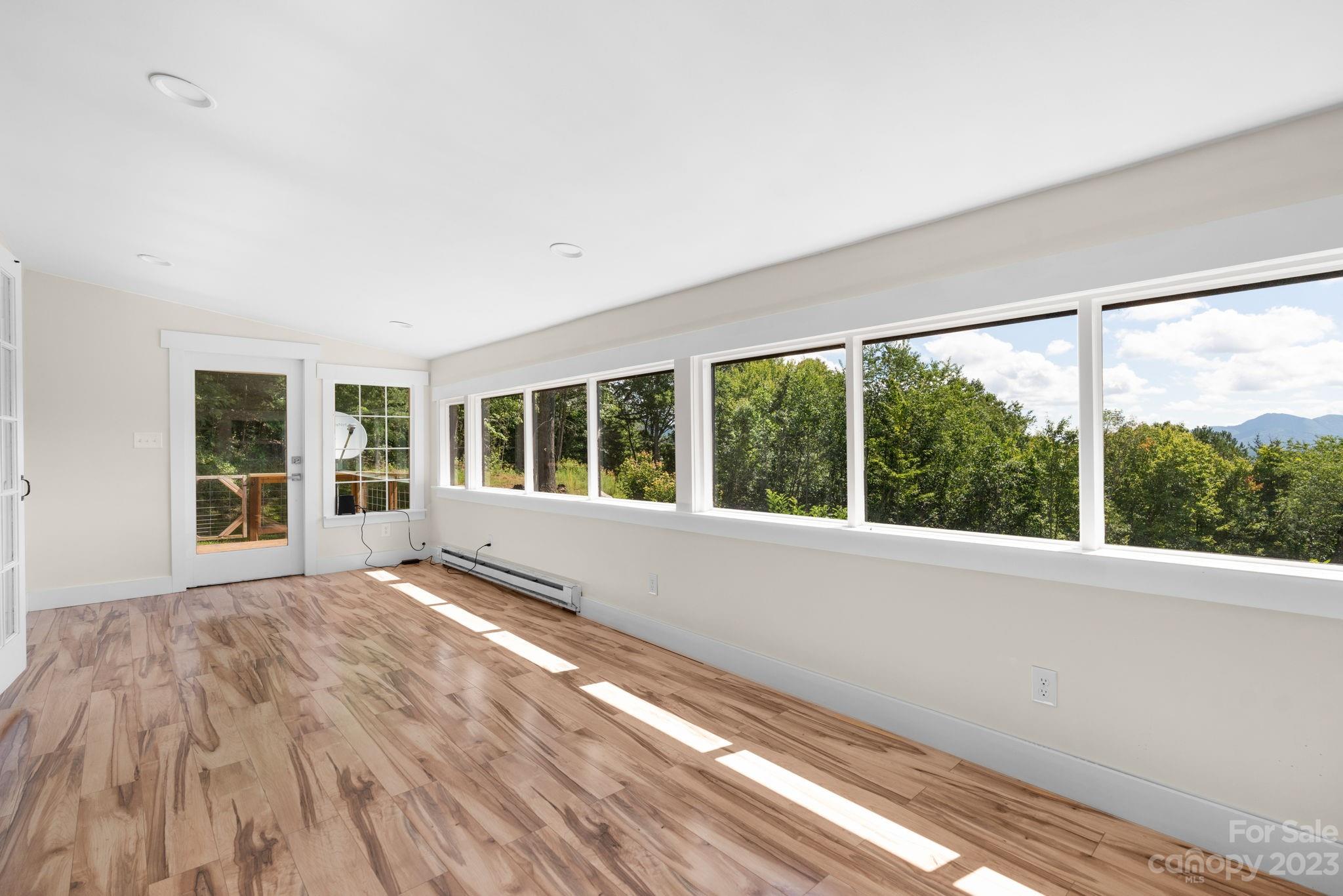 632 Thunder Road Clyde, NC 28721 - Photo 17 of 41 a view of an empty room with wooden floor and a window