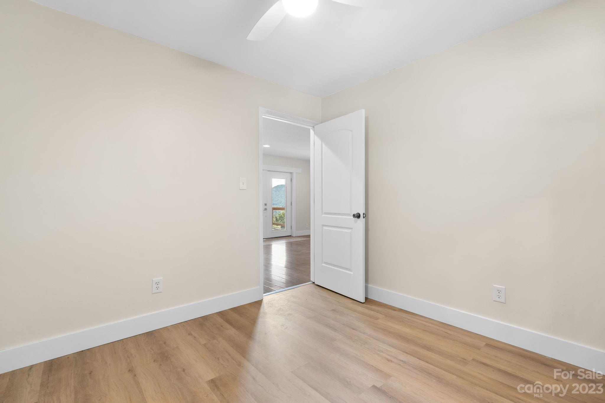 632 Thunder Road Clyde, NC 28721 - Photo 21 of 41 a view of an empty room with wooden floor and a window