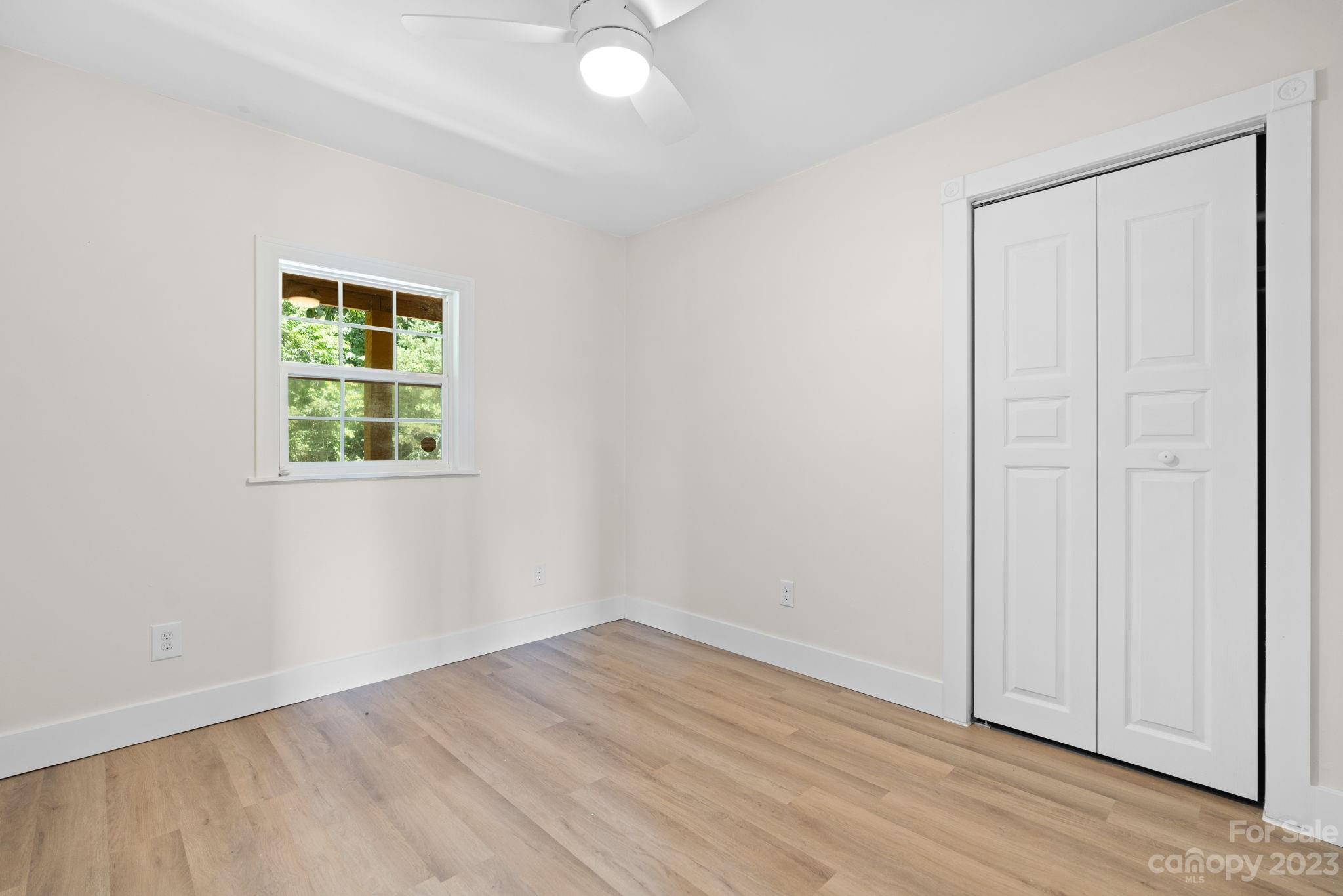 632 Thunder Road Clyde, NC 28721 - Photo 22 of 41 an empty room with wooden floor and windows