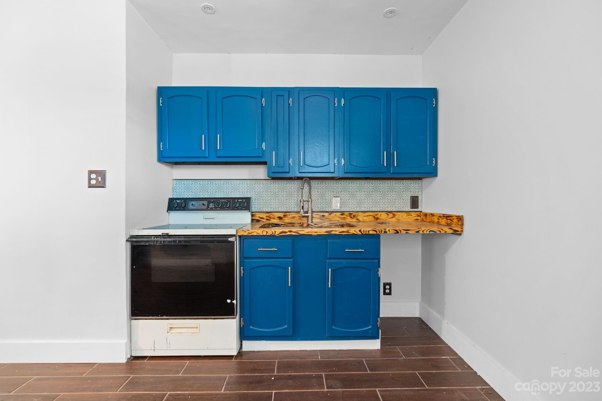 632 Thunder Road Clyde, NC 28721 - Photo 30 of 41 a kitchen with wooden cabinets and white appliances