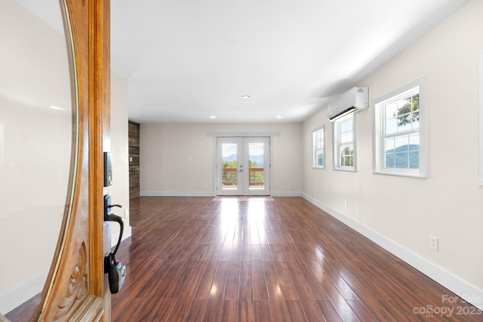 632 Thunder Road Clyde, NC 28721 - Photo 9 of 41 an empty room with wooden floor and windows