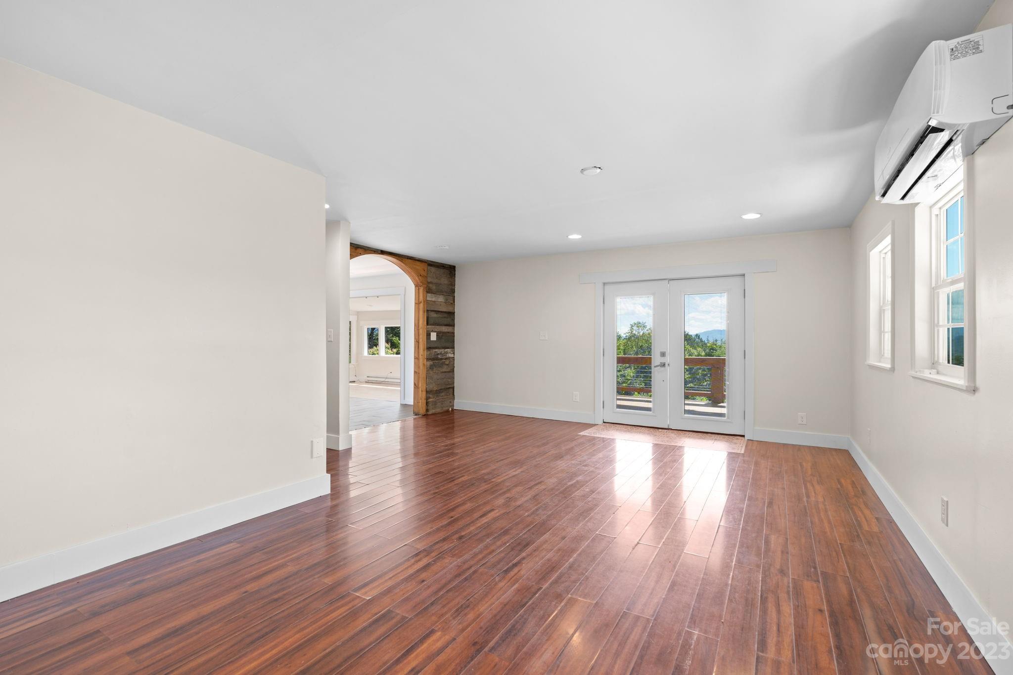 632 Thunder Road Clyde, NC 28721 - Photo 10 of 41 a view of a big room with wooden floor and windows