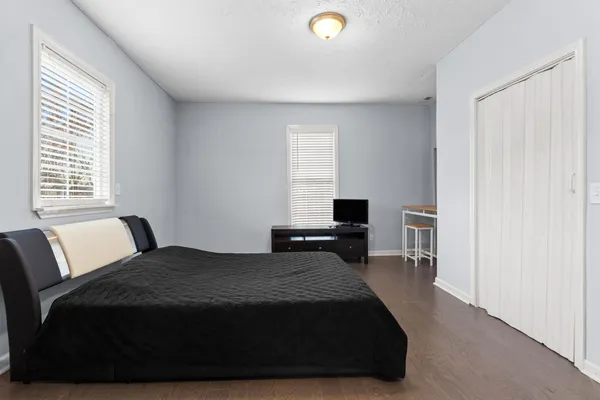 a bedroom with a bed and wooden floor