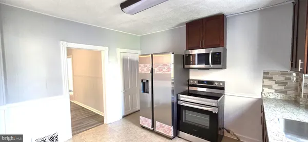 a kitchen with stainless steel appliances a stove a microwave and a refrigerator