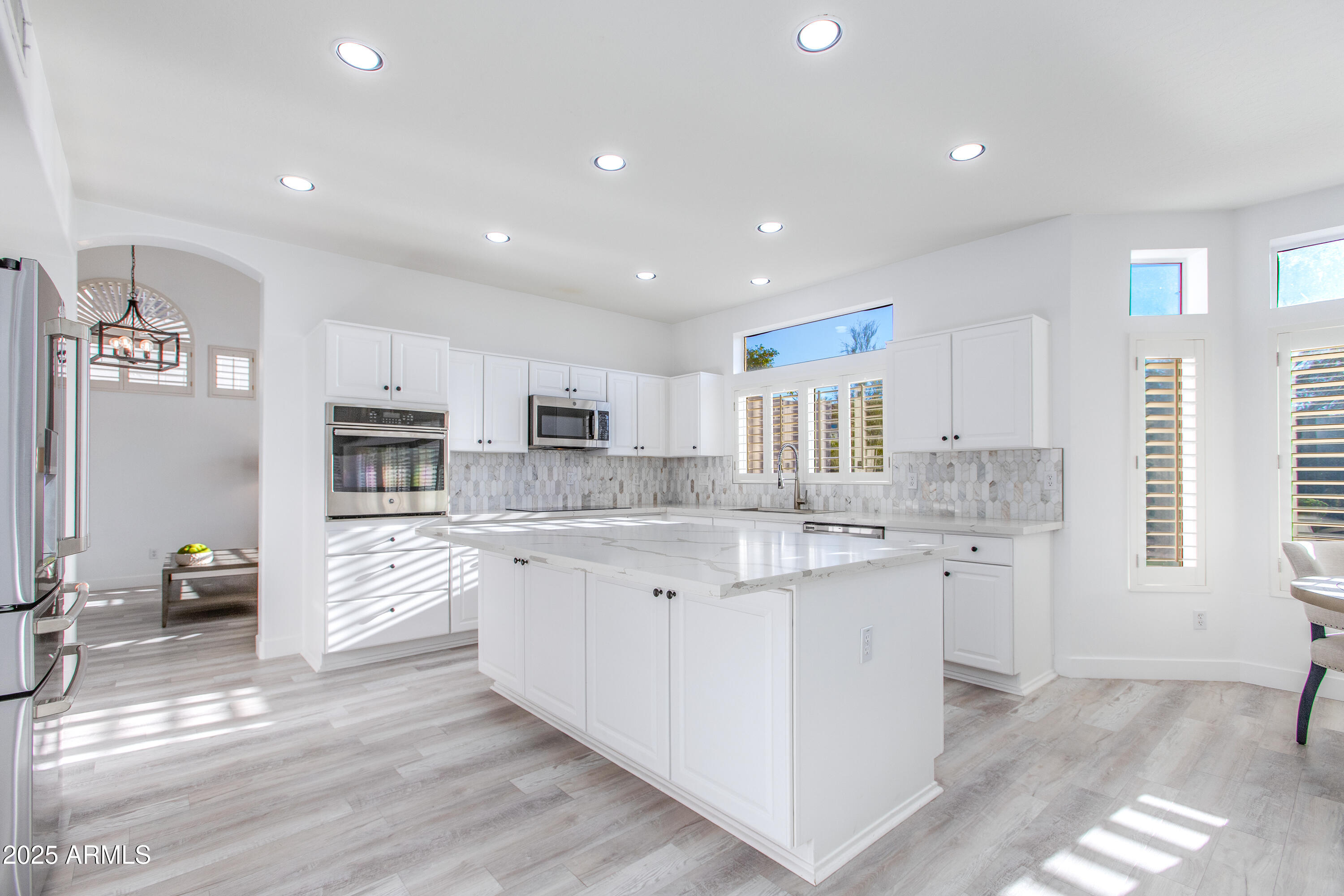 1331 East Voltaire Avenue Phoenix, AZ 85022 - Photo 5 of 33 a large kitchen with stainless steel appliances kitchen island granite countertop a sink and cabinets