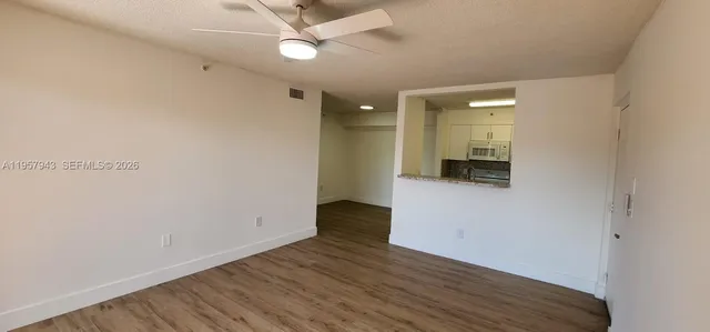 a view of an empty room with wooden floor