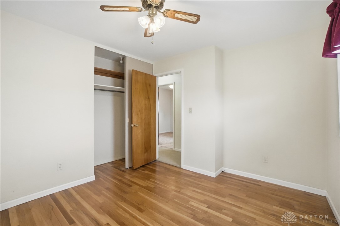 877 Woodhill Road Riverside, OH 45431 - Photo 20 of 42 This spacious bedroom features warm hardwood floors and a convenient open closet, offering both style and functionality.