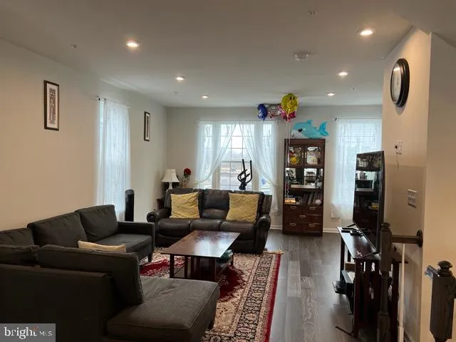 a living room with furniture a rug and kitchen view