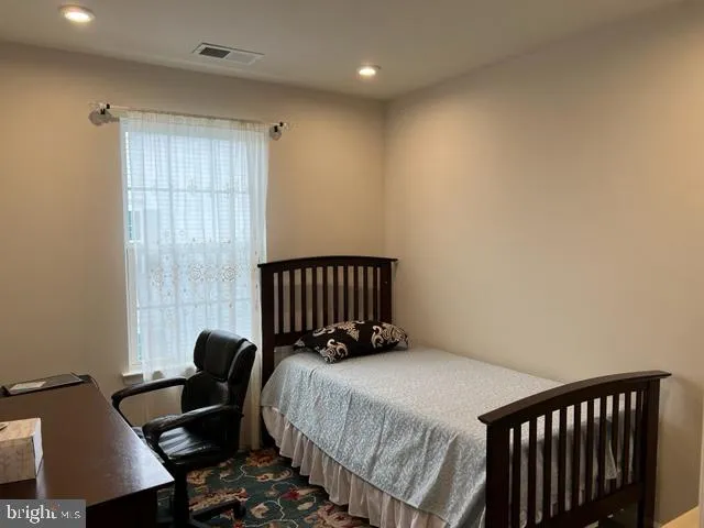 a bed sitting in a bedroom next to a window