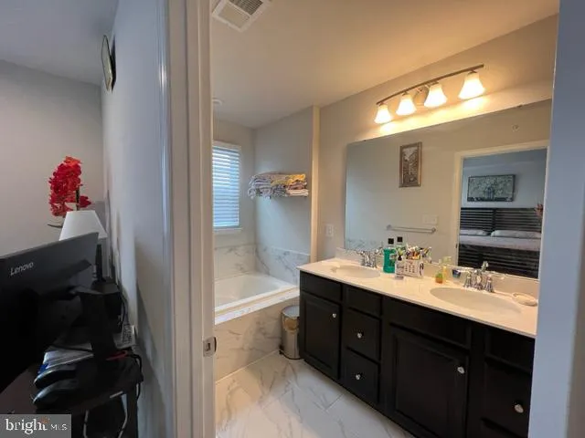 a en suite bathroom with a sink double vanity and a mirror
