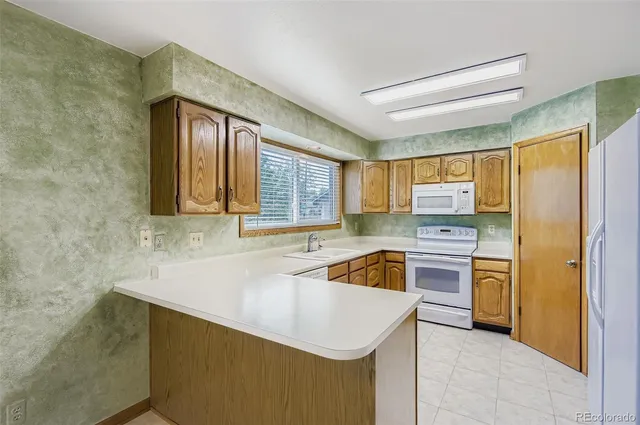 a kitchen with stainless steel appliances white cabinets sink and a window