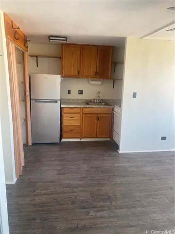 a kitchen with granite countertop a refrigerator and a sink