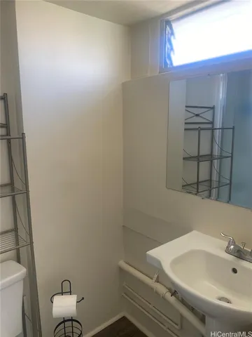 a bathroom with a sink and mirror with toilet