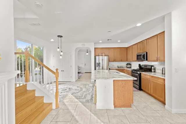 a kitchen with stainless steel appliances granite countertop a sink stove and refrigerator
