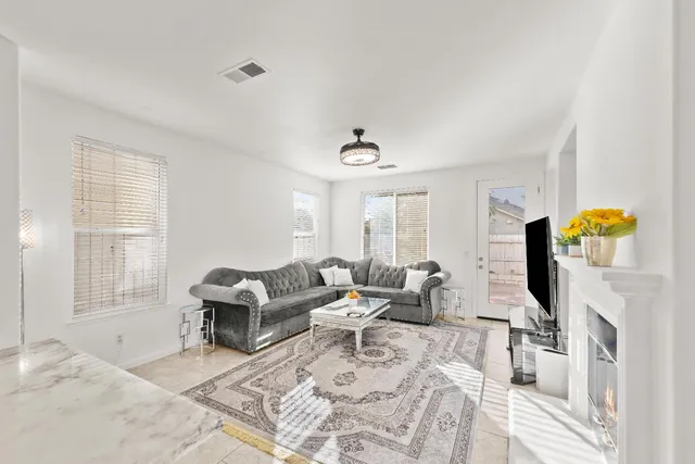 a living room with furniture a flat screen tv and a fireplace