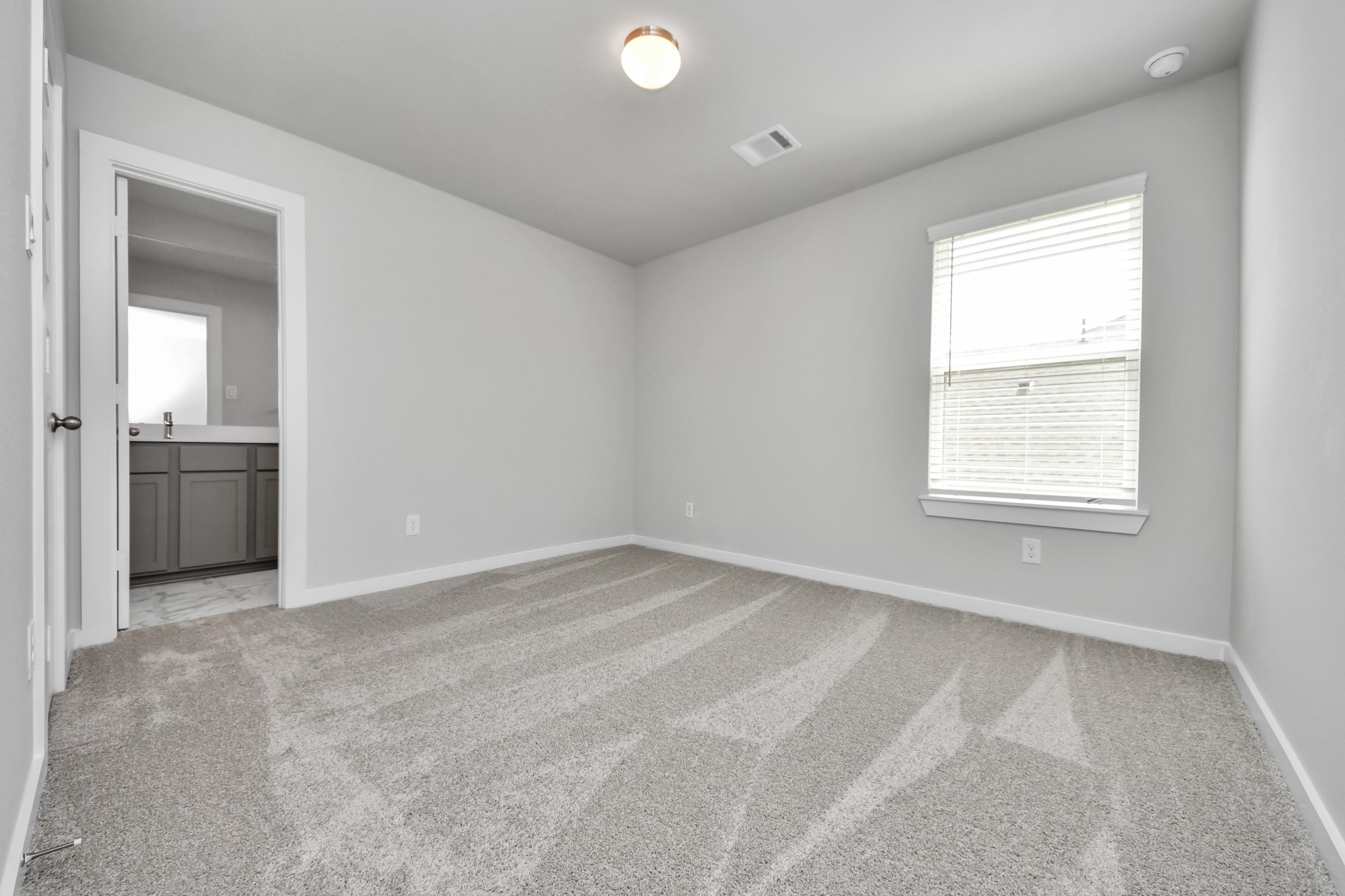 11106 Tulip Rdg Trail Houston, TX 77044 - Photo 30 of 34 Secondary bedroom features plush carpeting, large windows that let in plenty of natural light, bright paint, and spacious closets. Sample photo of completed home with similar floor plan. Actual colors and selections may vary.