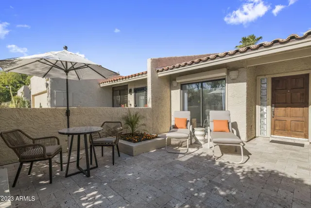 a backyard of a house with table and chairs
